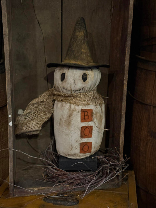 Scarecrow figure with a hat and wooden blocks in a rustic setting