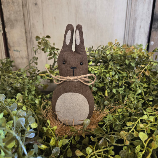 Decorative rabbit figure with a natural finish on a green leafy background