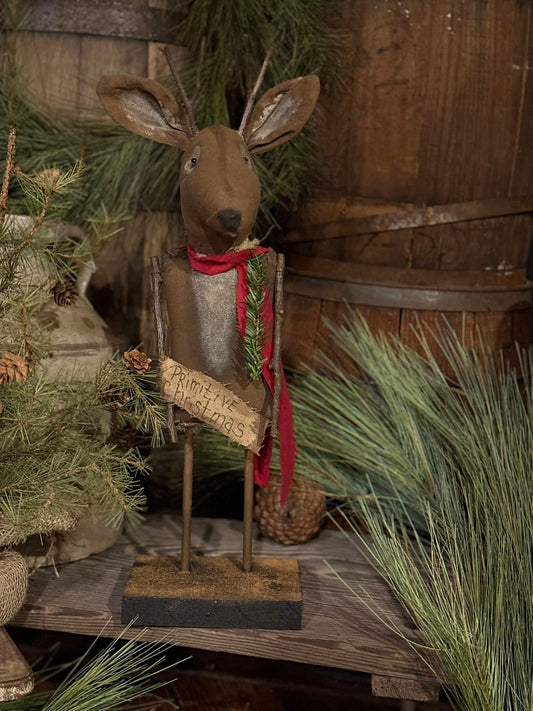 Decorative deer figure with a sign in a rustic setting