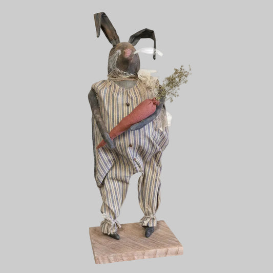 Decorative figure of a rabbit in a suit holding a carrot on a white background