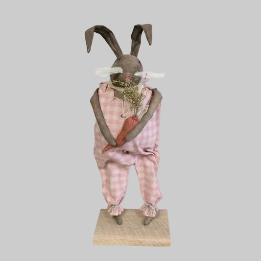 Decorative figure of a rabbit in a pink checkered outfit on a white background