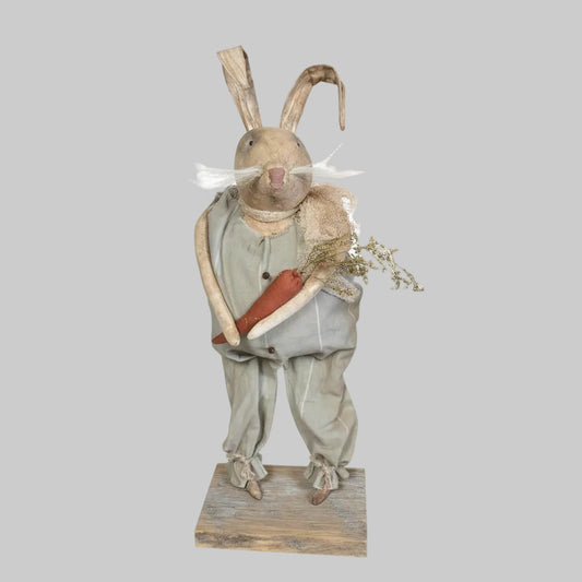Decorative bunny with carrot on wood base on a grey background