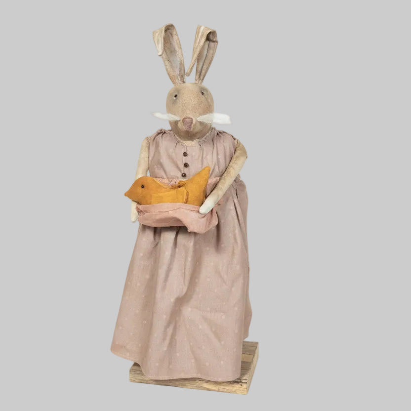 Decorative rabbit figure wearing a dress holding a teddy bear on a gray background