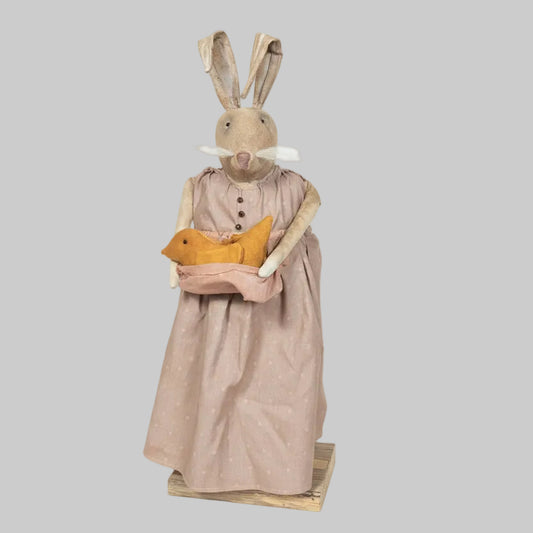 Decorative rabbit figure wearing a dress holding a teddy bear on a gray background