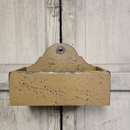Mustard wooden candle box against a wooden background