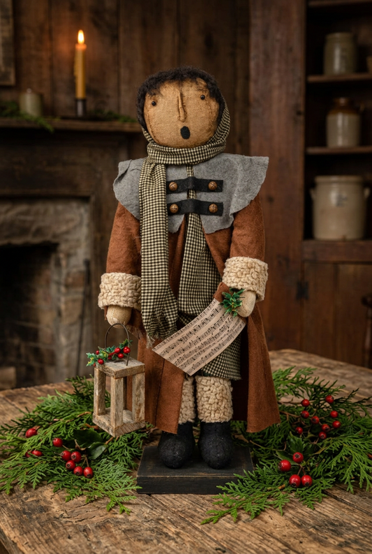 Primitive caroler on table with fresh cedar greens and berries.