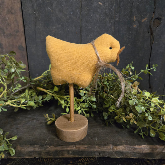 Yellow fabric heart with wooden stick on a dark wooden background