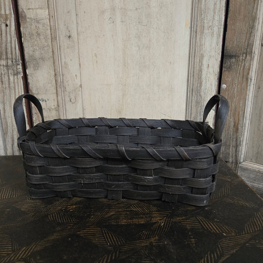 Woven black basket on a wooden surface