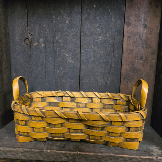 Woven mustard basket on a dark wooden background