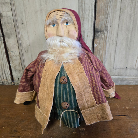 A figurine of a fat Santa Claus with a red suit and white beard, standing against a wooden background.