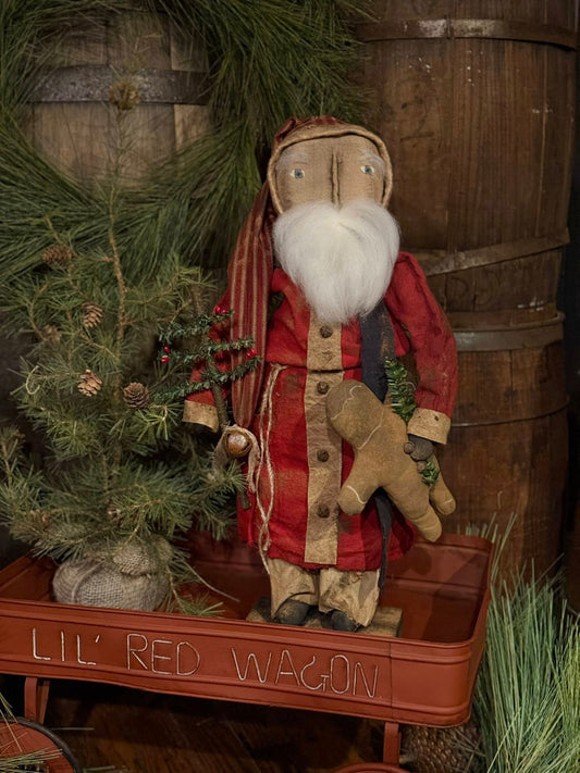 Vintage-style Santa Claus figure with a plaid coat in front of a wooden barrel and Christmas tree.
