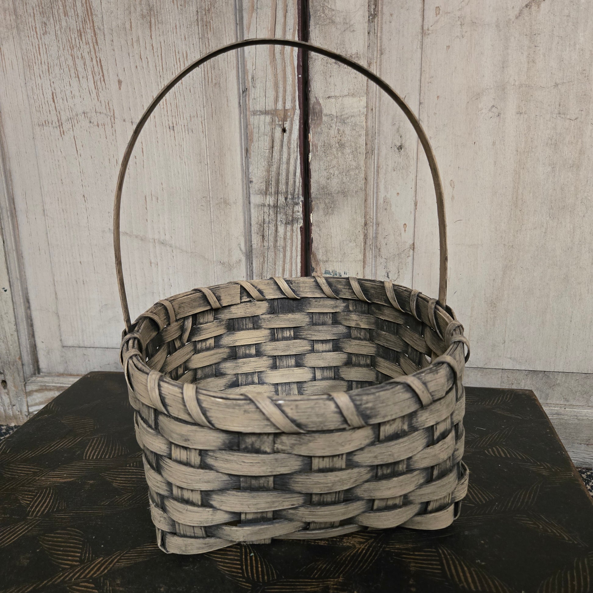 Woven basket with a handle on a wooden surface