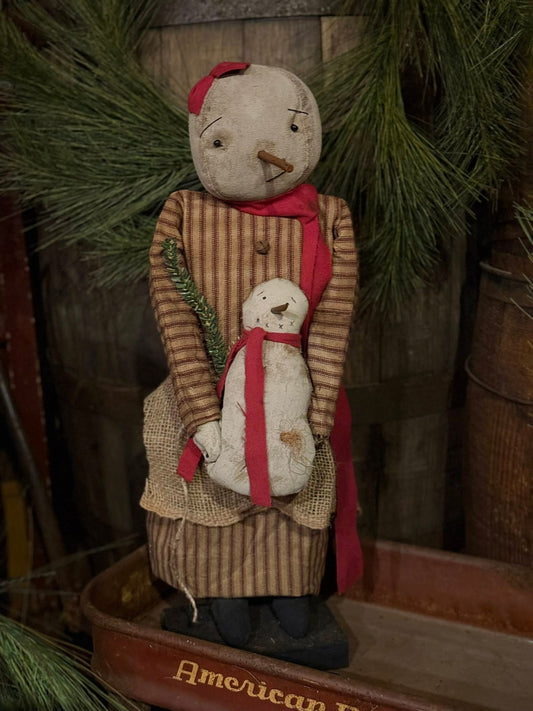 Vintage-style snowman figurine holding a smaller snowman figure, with a rustic background.