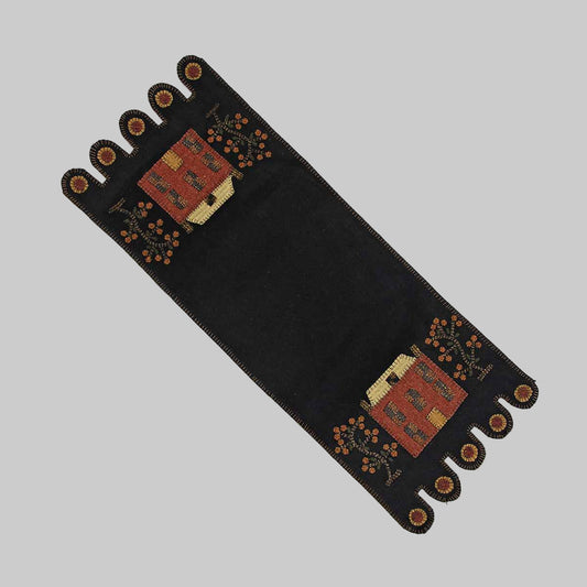 A black table runner with red and beige floral patterns and decorative elements at the ends.