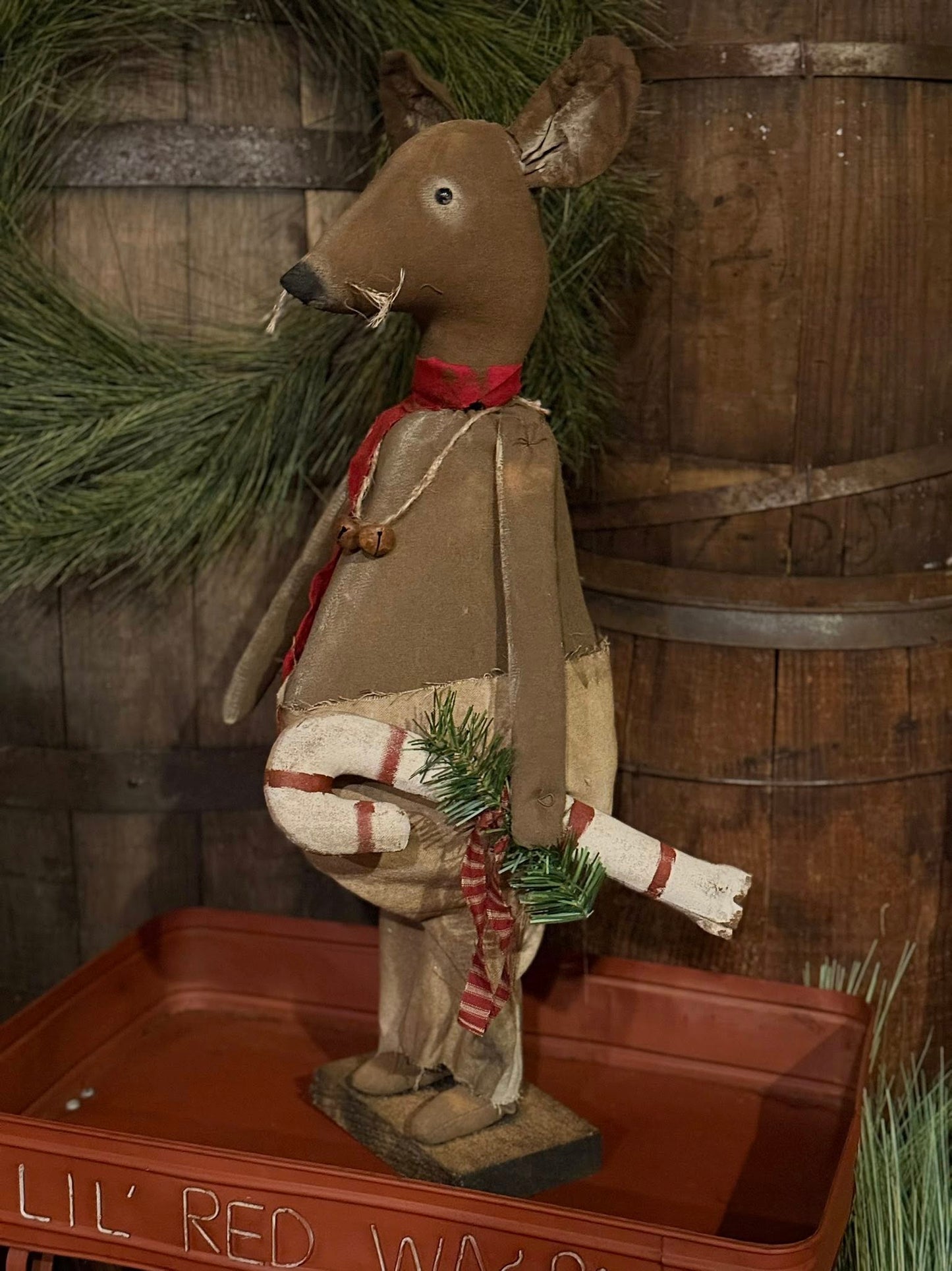 Decorative deer figure with a wreath against a wooden background