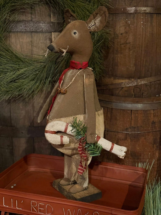 Decorative deer figure with a wreath against a wooden background