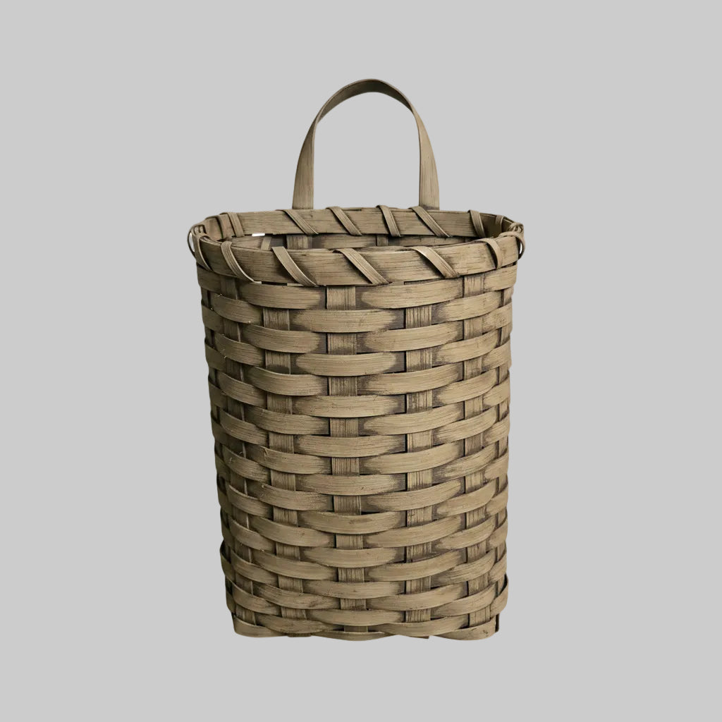 Woven basket with handles on a gray background
