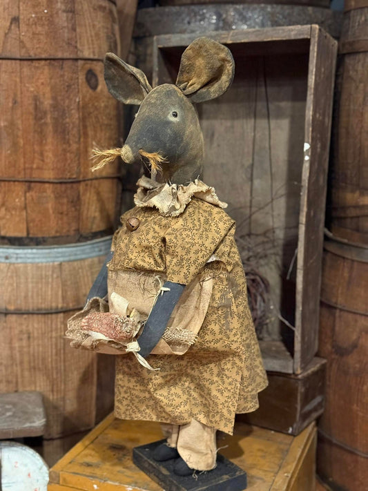 Vintage mouse figure in a rustic setting with wooden barrels and crates.