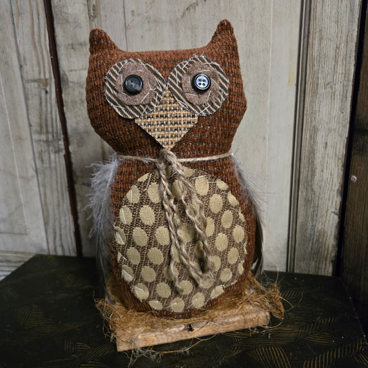 Decorative owl made of fabric with polka dot pattern on a wooden background