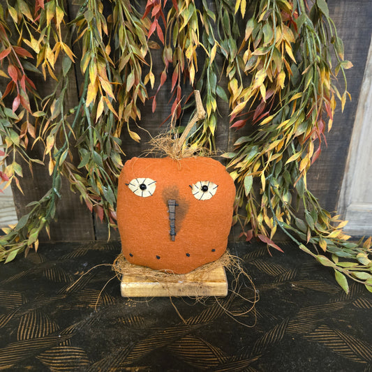 Decorative pumpkin with leafy branches on a textured background