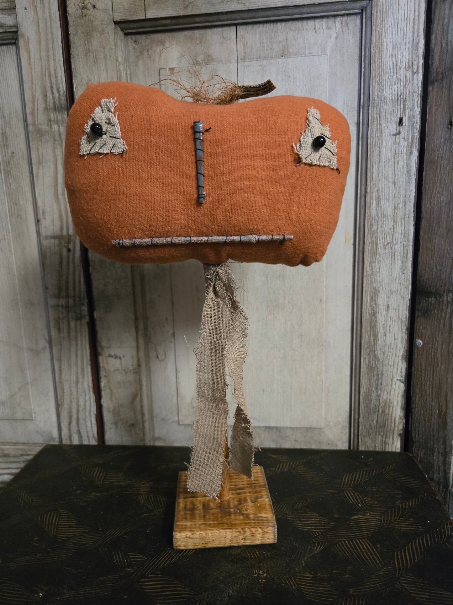 Pumpkin head on a wood stand on a rustic background