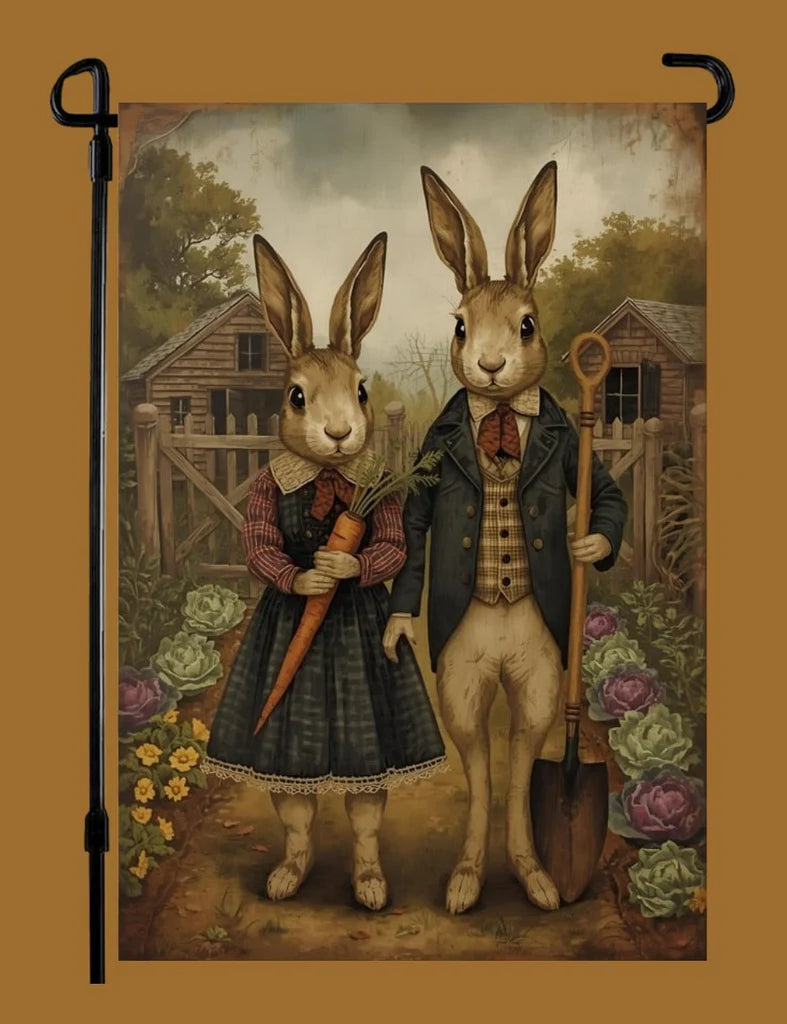 Decorative garden flag with rabbits in human clothing holding an umbrella and shovel.