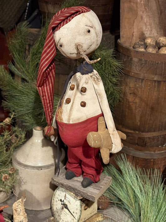 Vintage-style snowman with a striped headscarf and red pants in a rustic setting