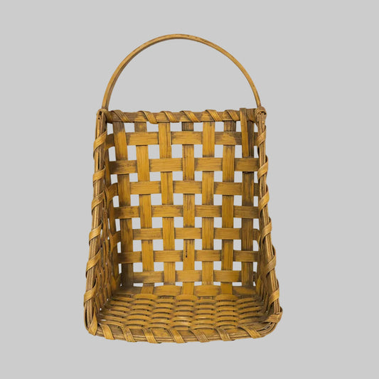 Woven basket with a handle on a wooden surface