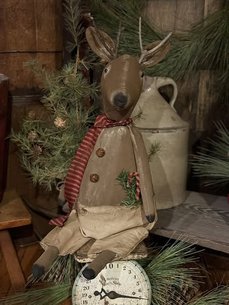 Decorative reindeer figure with a striped scarf in a rustic setting