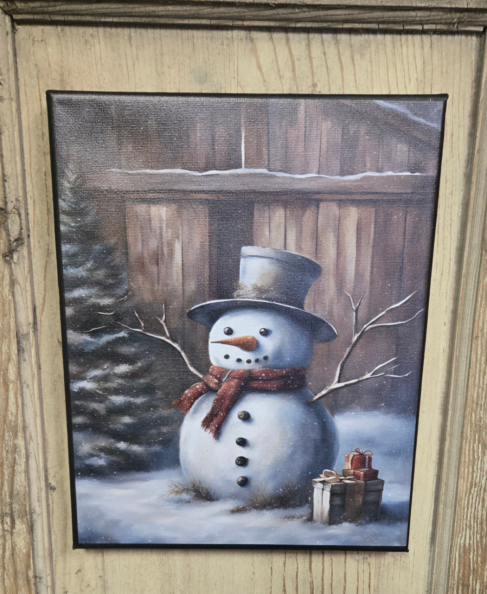 A canvas print featuring a primitive style snowman with gifts, set against a wintery backdrop.