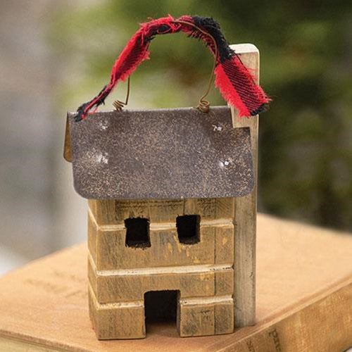Wooden birdhouse with a red and black ribbon on a wooden surface
