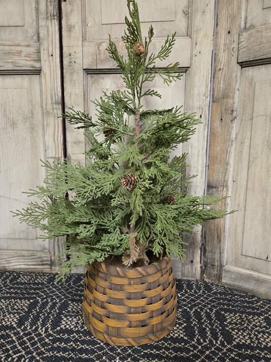 A small mustard-colored primitive basket tree collar displayed with a twig tree.