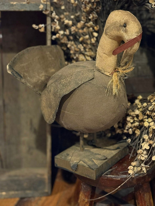 Decorative goose figure on a stand with a blurred background