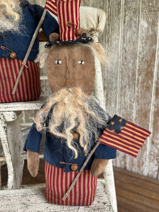 Decorative figure resembling Uncle Sam with an American flag against a wooden background