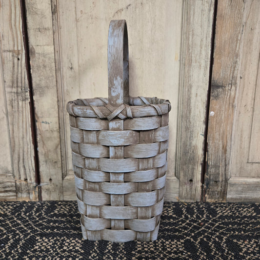 Blue basket sitting on table runner in front of a weathered wood piece