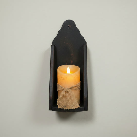 Decorative wall sconce with a candle on a wooden surface
