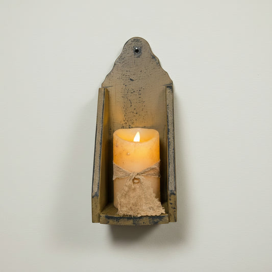 Vintage-style wall sconce with a lit candle on a rustic wooden background