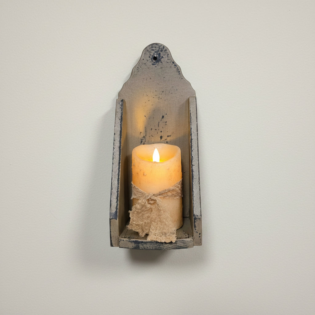 Wooden wall sconce with a lit candle on a rustic wooden background
