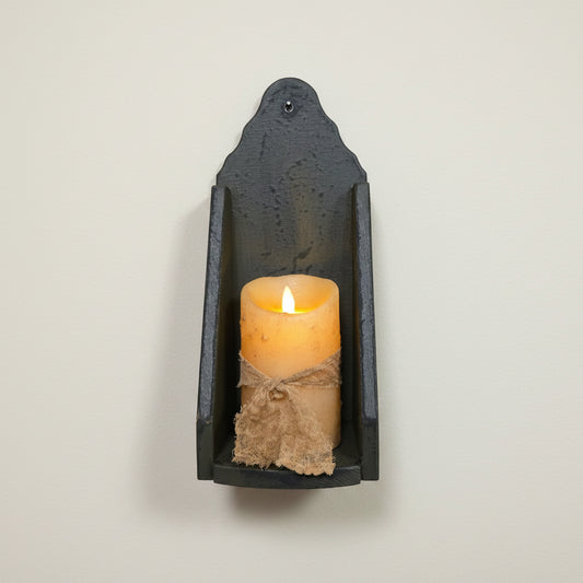 Candle in a wood wall sconce on a wall
