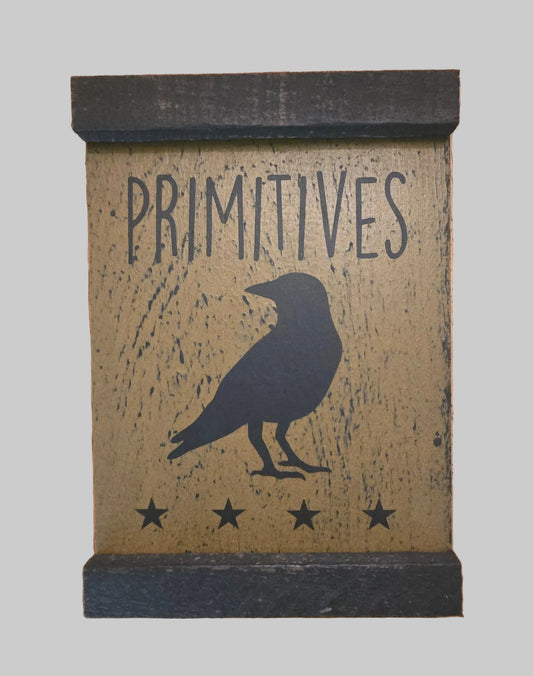 Decorative sign with 'PRIMITIVES' text and crow silhouette on a wooden background