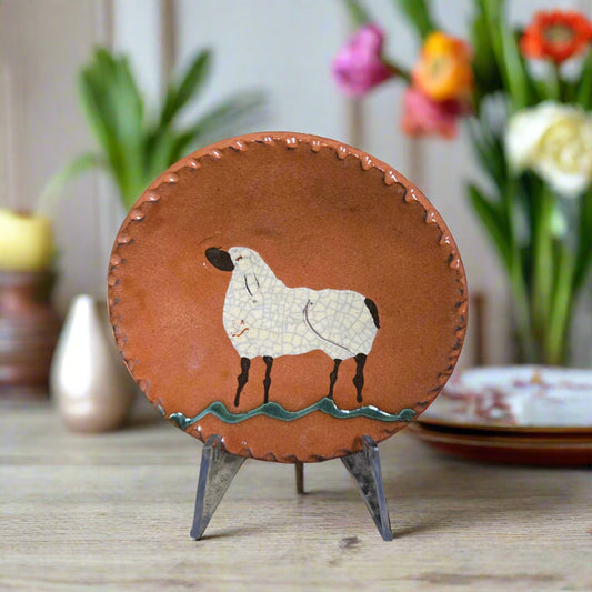 Small round redware plate with a sheep and interesting edging