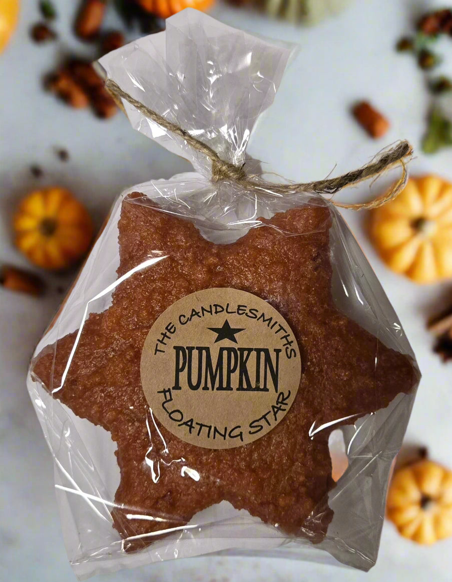 A pumpkin-shaped floating candle with a label that reads 'The Candlesmiths Pumpkin Large Star'.