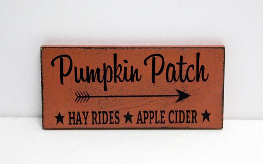 Wooden sign with 'Pumpkin Patch' text and arrow on a white background