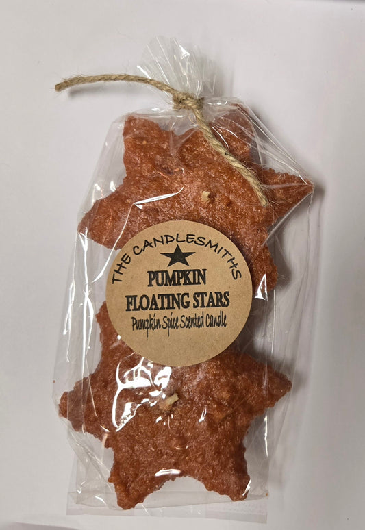 Two star-shaped floating candles with a pumpkin scent, packaged in clear wrapping with a label.