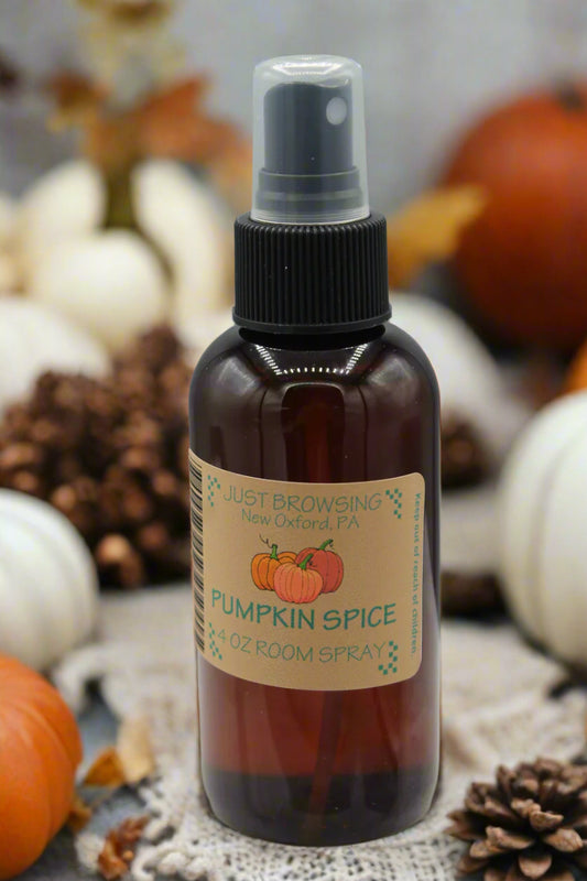 Brown glass bottle with pumpkins on label with pinecones and pumpkins in the background