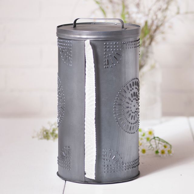 Punched tin paper towel holder with chisel design with greenery in background