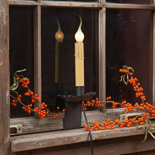 Decorative candles with berries on a rustic wooden surface