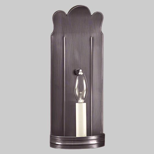Decorative wall sconce with scalloped design on a beige wall