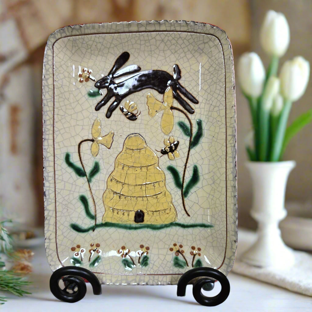 Decorative ceramic tray with rabbit and leaf design on a wooden surface