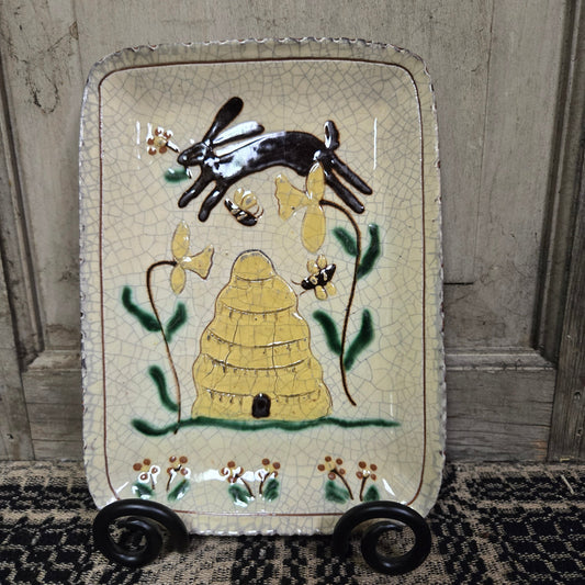 Decorative ceramic tray with rabbit and leaf design on a wooden surface
